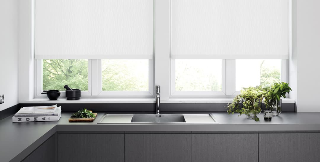 White PVC roller blinds above a kitchen sink