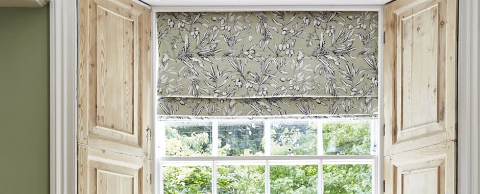 Beige and white floral patterned roman blinds in cottage window