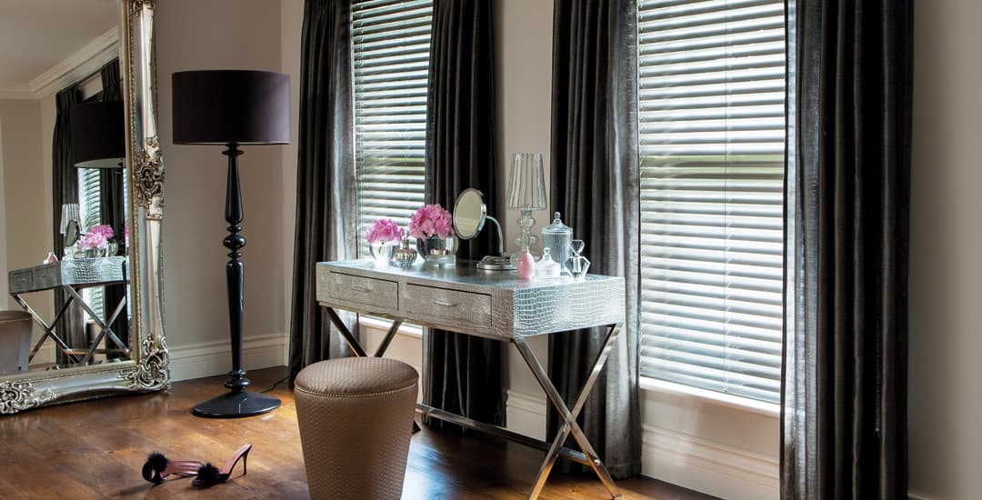 Dark real wooden blinds and curtains in a luxurious bedroom