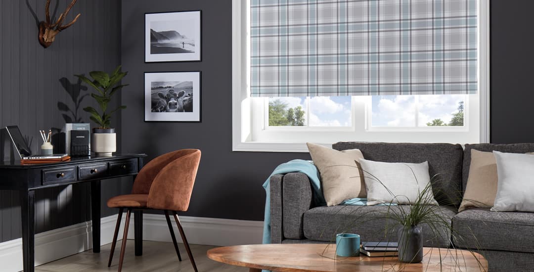Light blue and grey tartan patterned roller blinds in dark grey living room