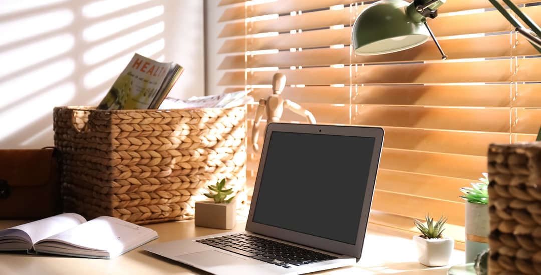 Light real wooden venetian blinds in a sunny home study window