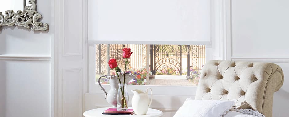 White blackout roller blinds in a traditional sitting room