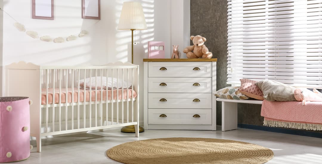 White faux wood blinds in baby’s nursery