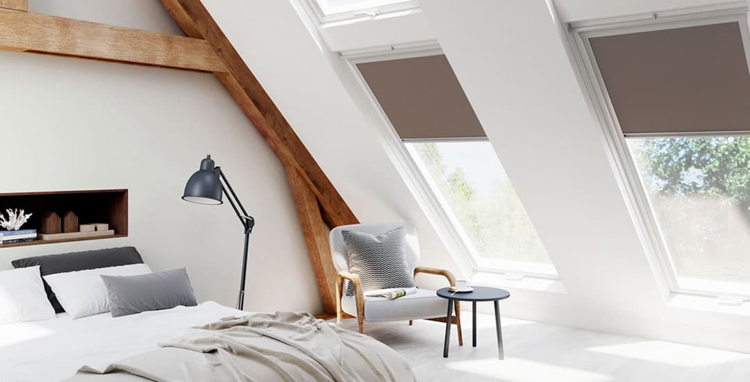 Brown Velux blinds in a converted attic bedroom