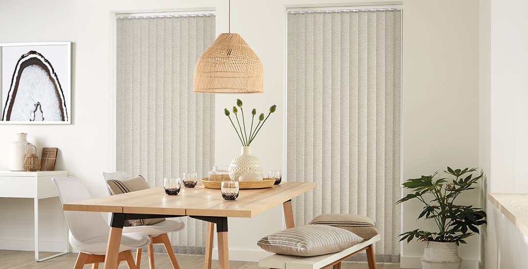 Closed beige textured vertical blinds in a dining room