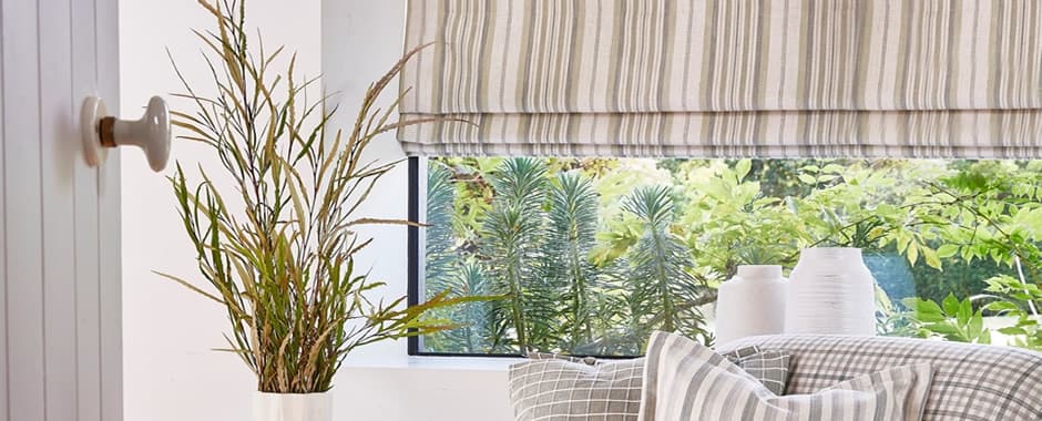 Closeup of beige vertical striped roman blinds in a window