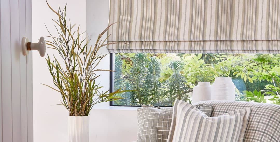 Closeup of beige vertical striped roman blinds in a window