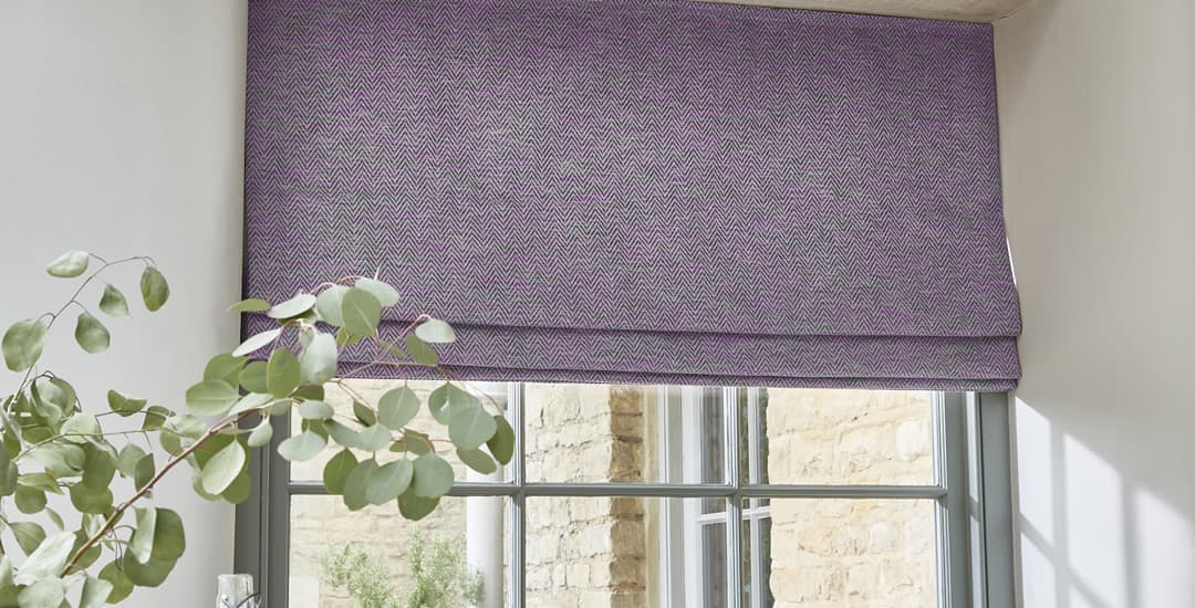 Closeup of luxury purple roman blind in window