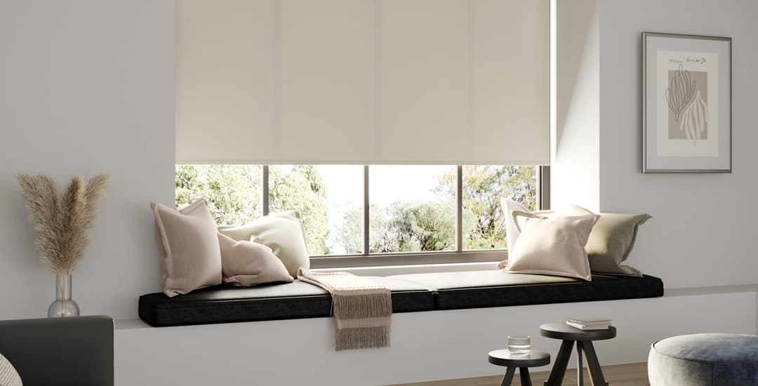 Cream textured roller blinds above window seat