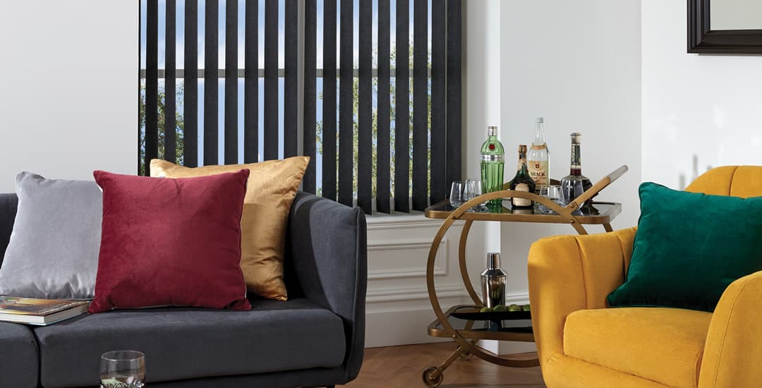 Partially opened black vertical blinds in traditional sitting room window