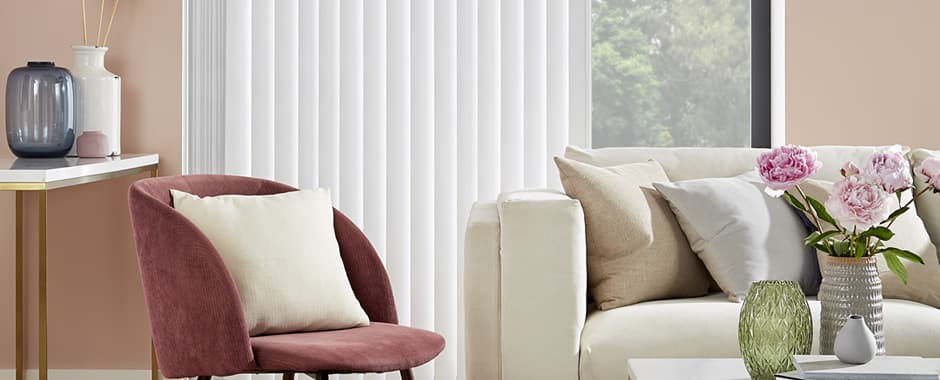 Partially opened white blackout vertical blinds at a living room patio