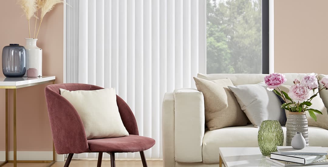 Partially opened white blackout vertical blinds at a living room patio