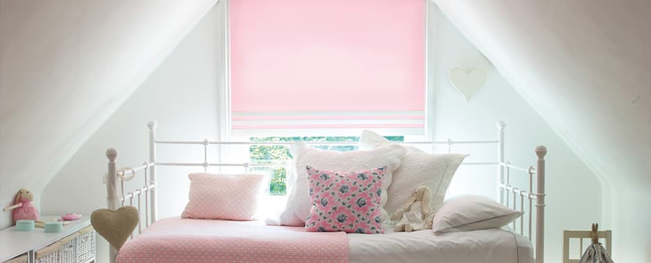 Pink roller blinds in a children’s attic bedroom