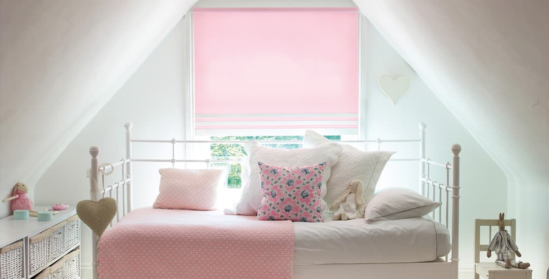 Pink roller blinds in a children’s attic bedroom