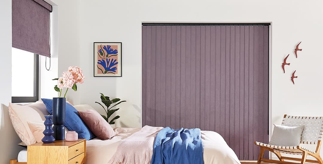 Purple faux suede vertical blind and roller blinds in the same bedroom