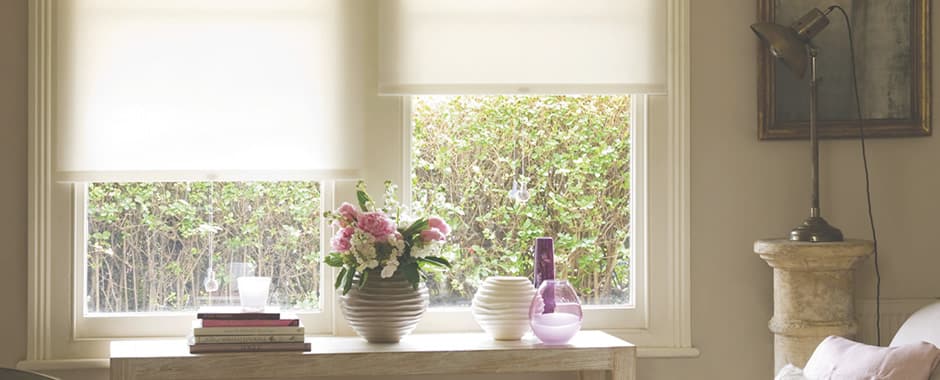 White dimout roller blinds in cosy sunny sitting room