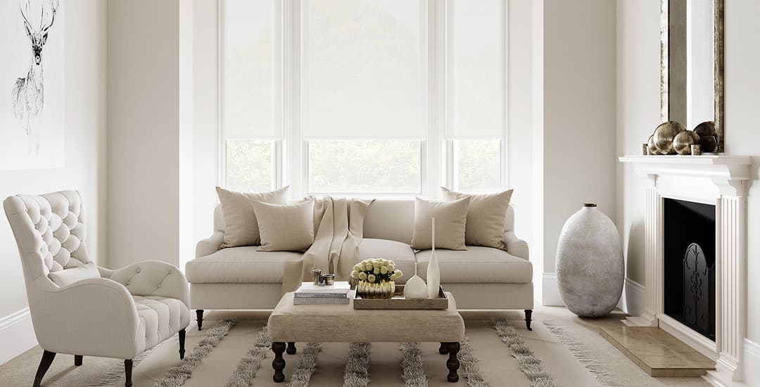 White roller blinds in bay window of cream living room