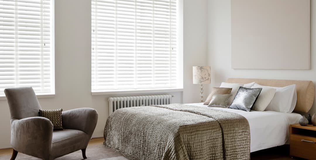 White wooden blinds with tapes in a contemporary bedroom