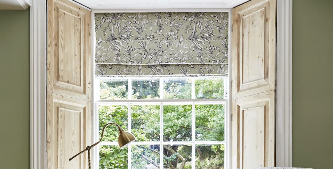 Beige and white floral patterned roman blinds in cottage window