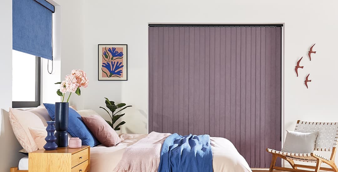 Blue and purple faux suede vertical blind and roller blinds in same bedroom