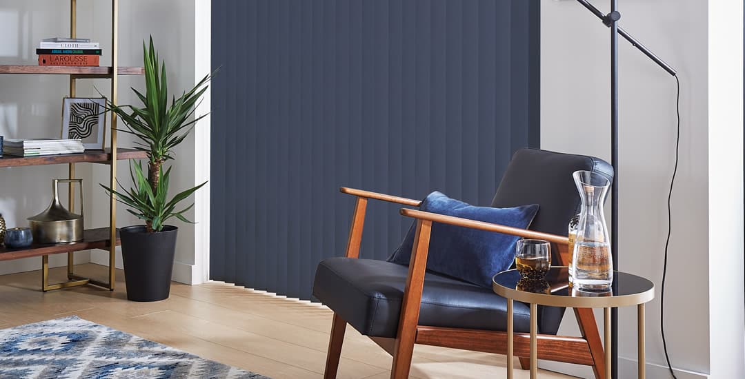 Closed blue thermal blackout vertical blinds at living room patio doors