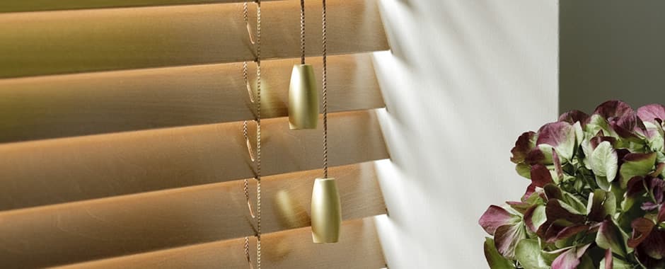 Closeup of closed honey wooden blinds in a sunny window