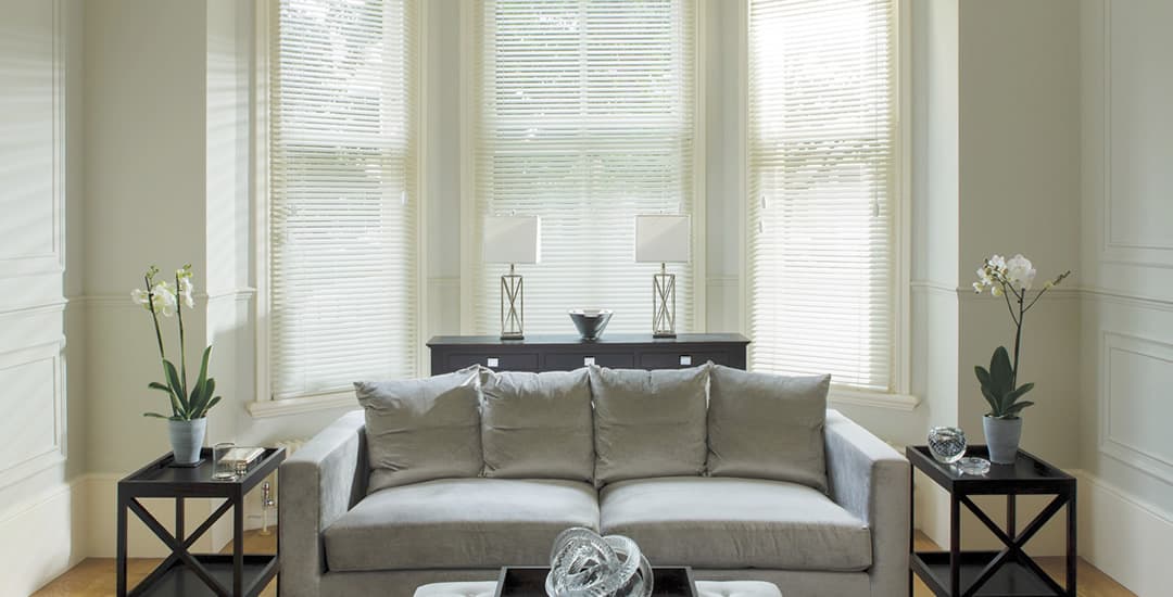 Cream wooden blinds in living room bay window