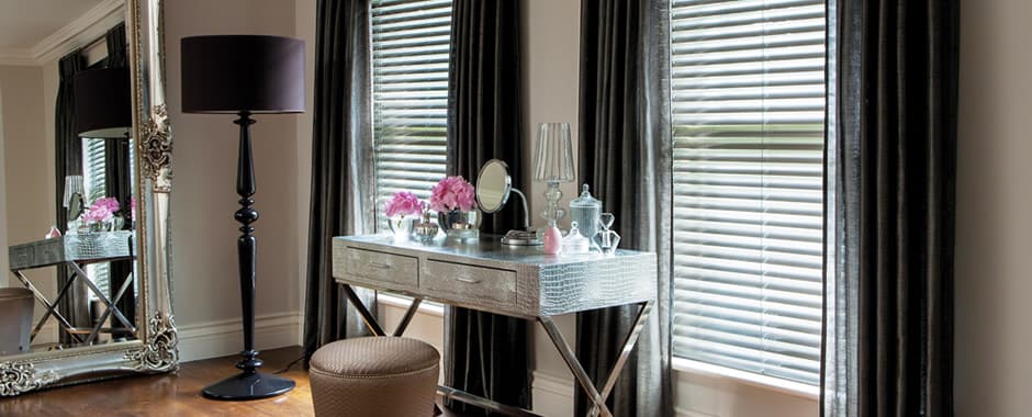 Dark real wooden blinds-and curtains in a luxurious bedroom