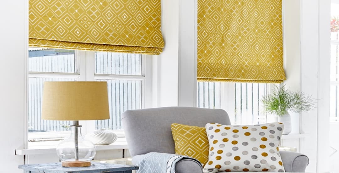Golden yellow patterned dimout roman blinds in a living room