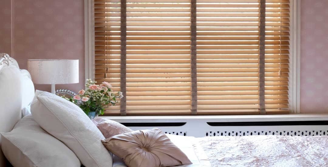 Partially closed wooden blind with tapes in a bedroom