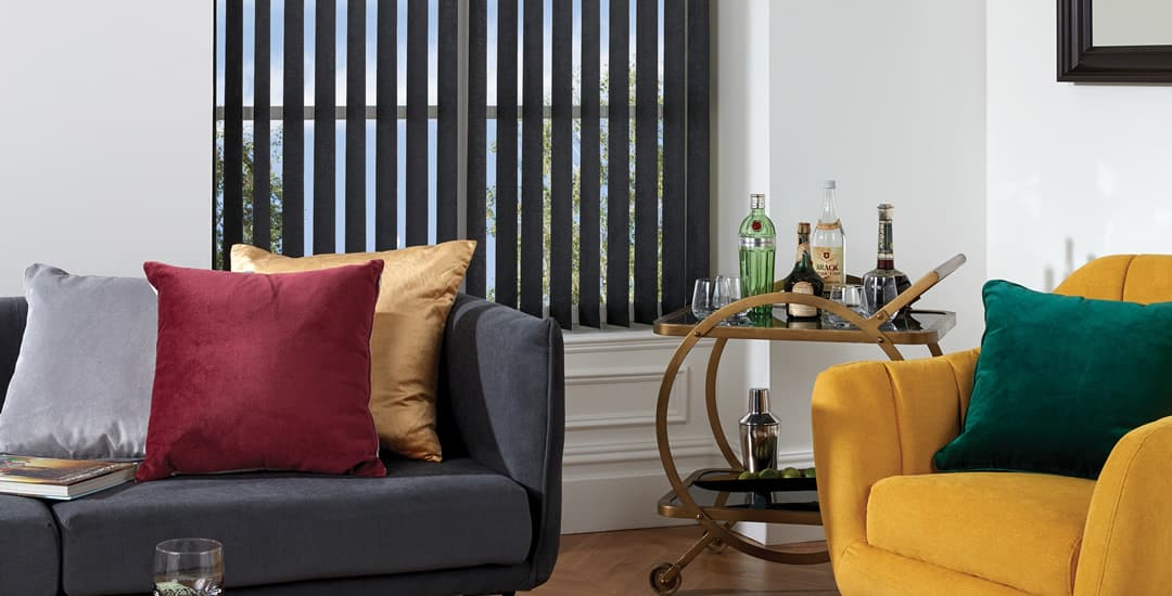 Partially opened black vertical blinds in sitting room with view
