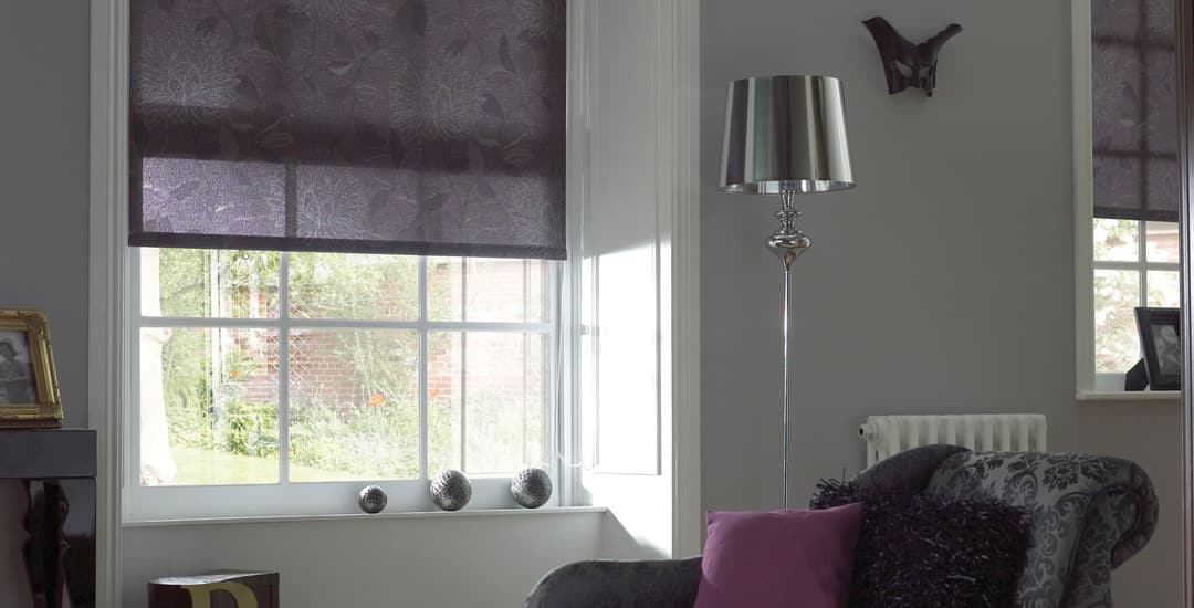 Purple patterned room darkening roller blinds in a sitting room