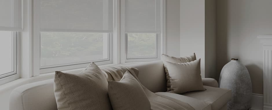 Sheer roller blinds in a living room at dusk