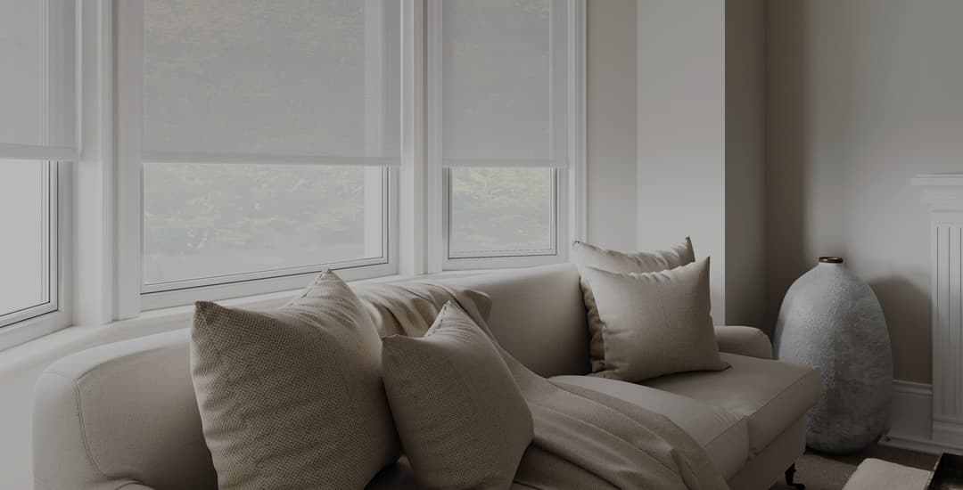 Sheer roller blinds in a living room at dusk