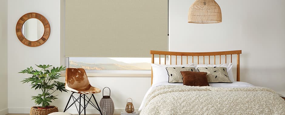 Beige textured roller blind in a cosy cream bedroom