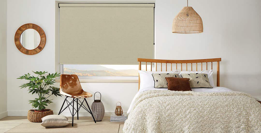 Beige textured roller blind in a cosy cream bedroom