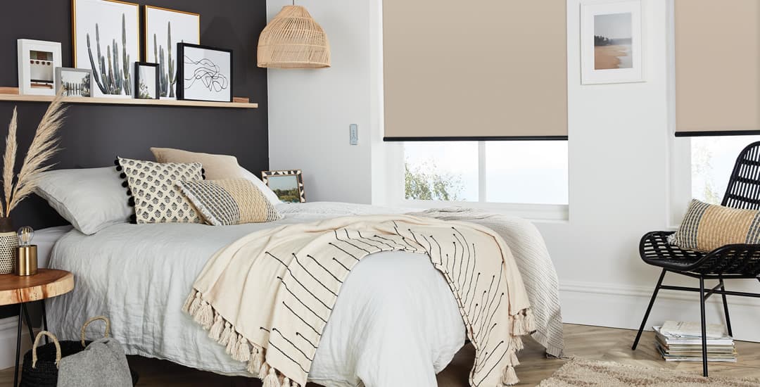 Beige thermal blackout roller blinds in a cosy bedroom
