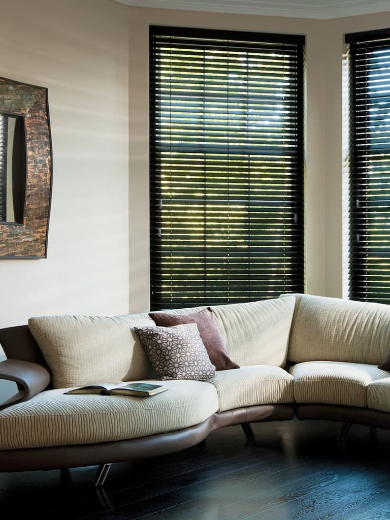 Black wooden Venetian blinds in a contemporary cream living room