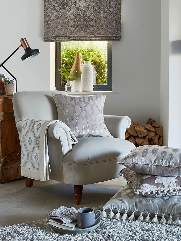 Bohemian grey patterned roman blind in a small cottage living room