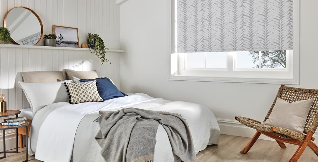 Grey leaf patterned thermal roller blinds in a cosy wood-panelled bedroom