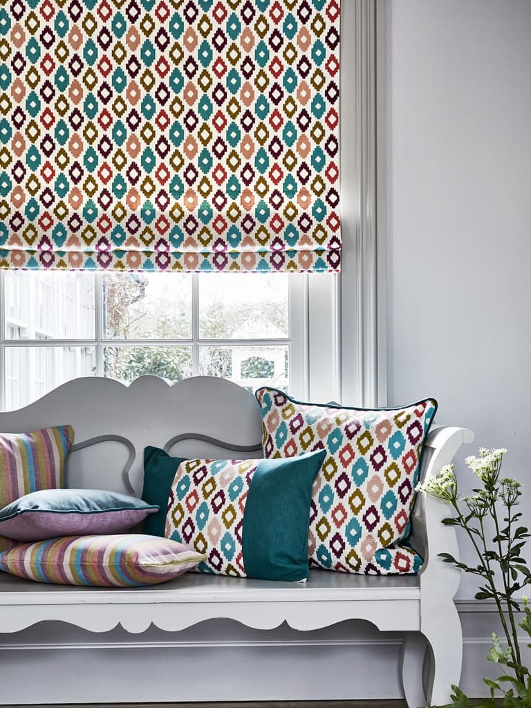 Ikat inspired geometric patterned roman blind in a living room window