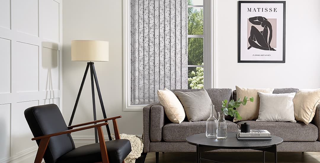 Silver patterned vertical blinds in a modern grey and white living room