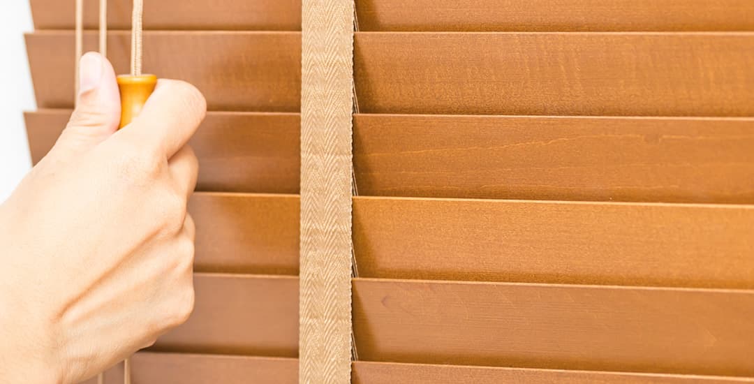 Closeup of a real wooden blind with slats being closed upwards