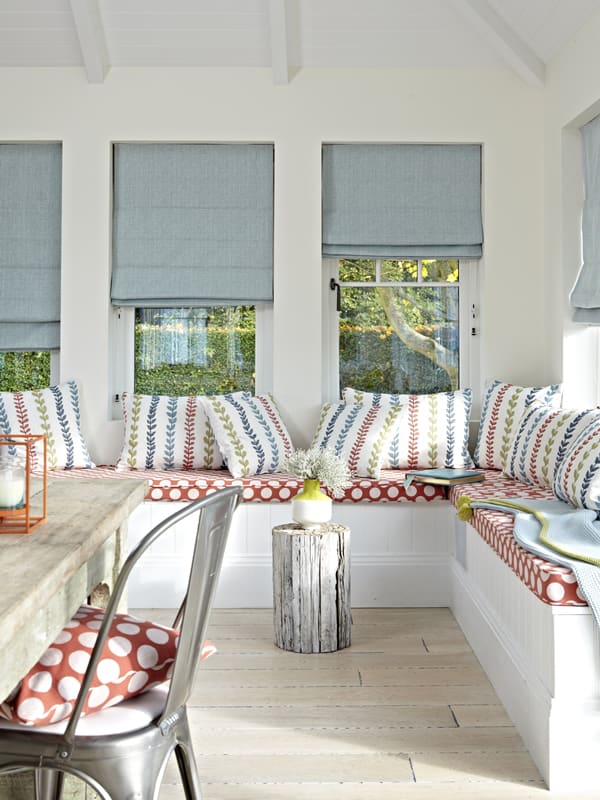Luxury blue grey fabric roman blinds in stylish bright dining room