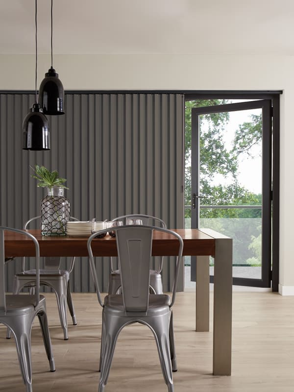 Dark grey vertical louvre window blinds in dining room patio doors