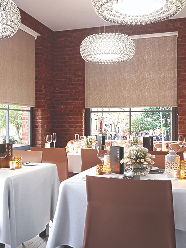 Beige textured blackout roller blinds in restaurant