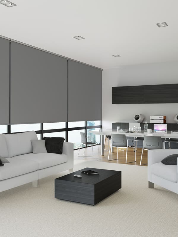 Grey fire-resistant blackout commercial roller blinds in office